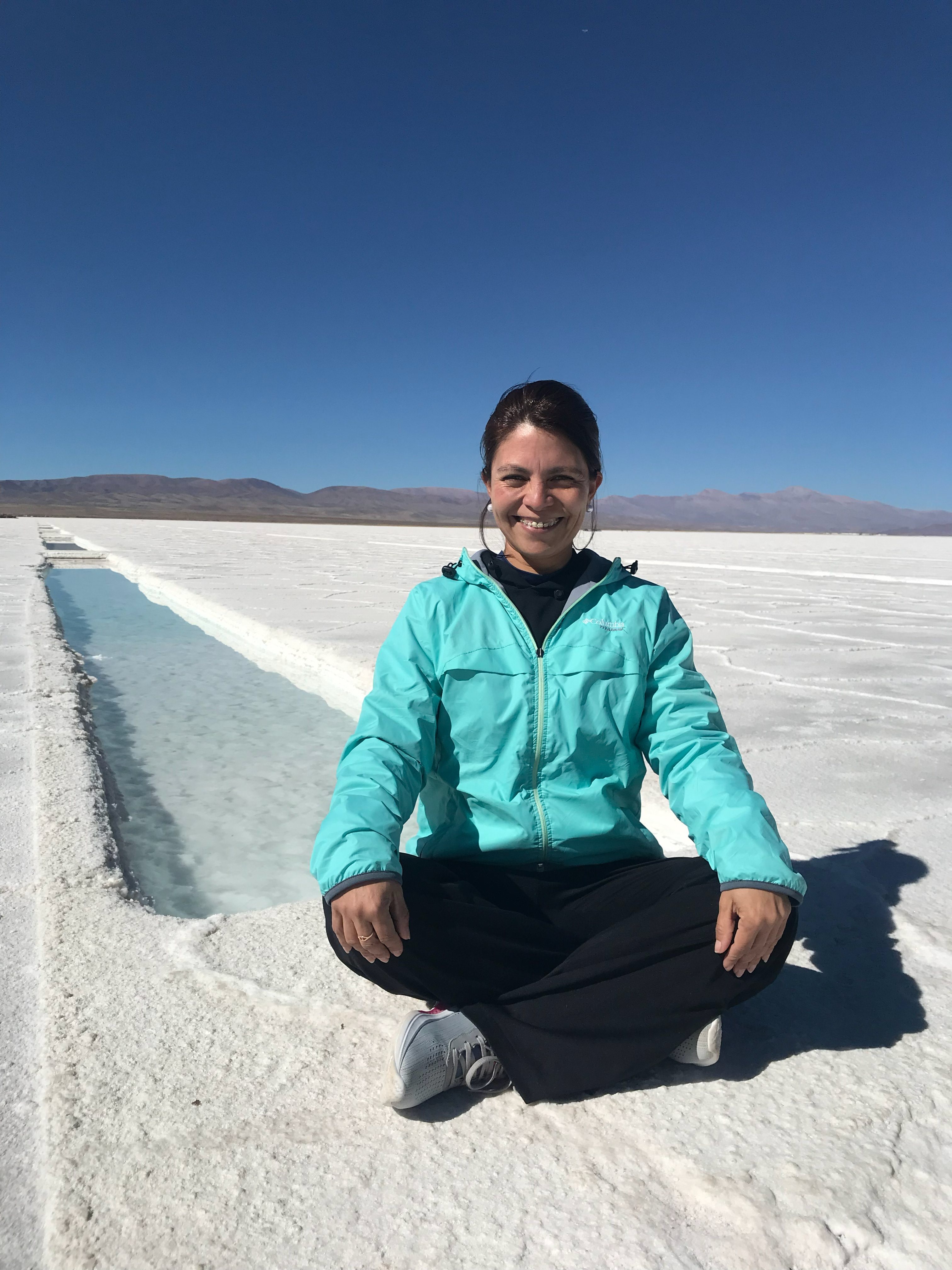 Cecilia Araoz sentada en las Salinas Grandes, Jujuy, Argentina